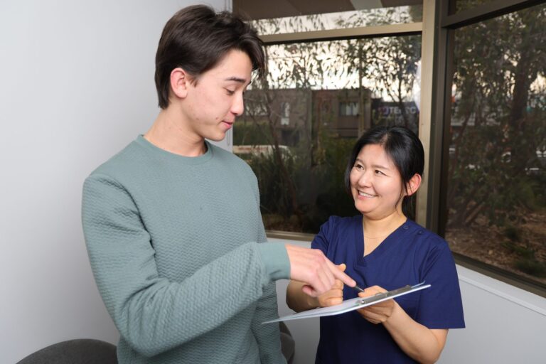 Dental team member explaining health fund paperwork to a patient