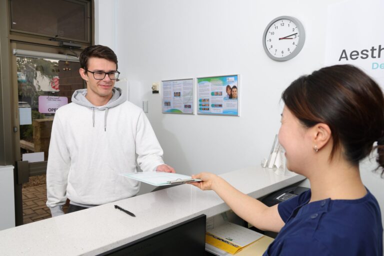Dental team member giving a patient a form